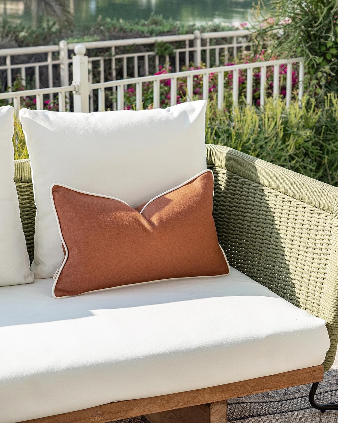 Aelia Clay II cushion in rust, shown in a lifestyle left view as image 2