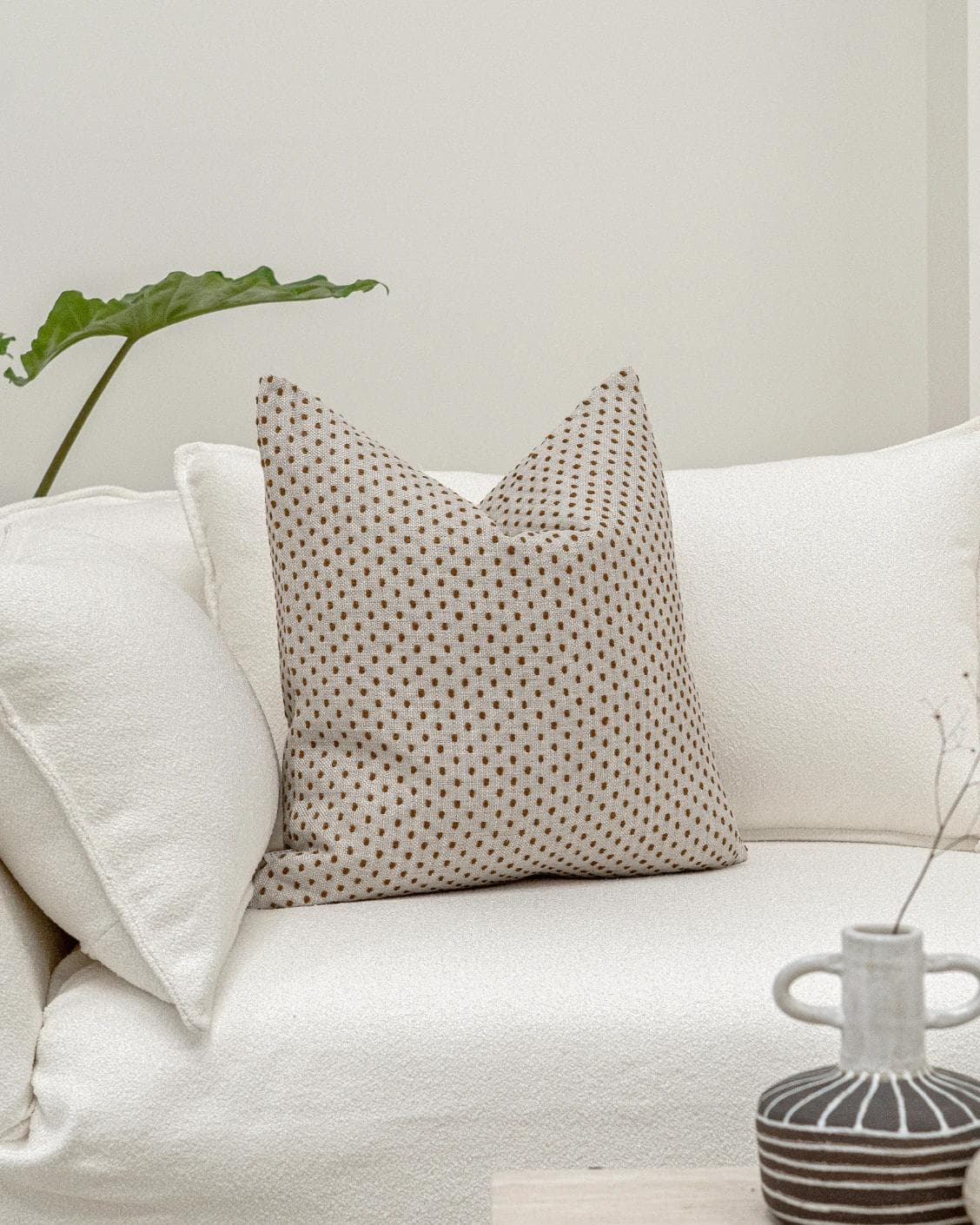 Dotty Rust cushion in beige, shown in a lifestyle front view as image 2