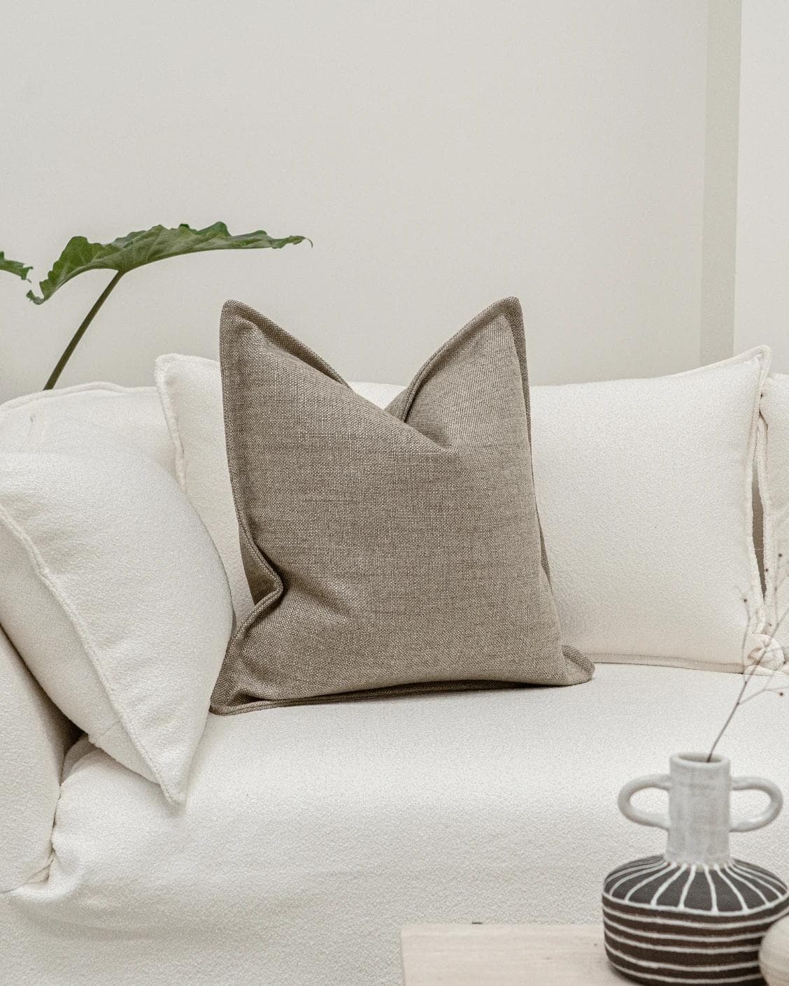 Emmett Quell cushion in taupe and grey, shown in a lifestyle front view as image 2