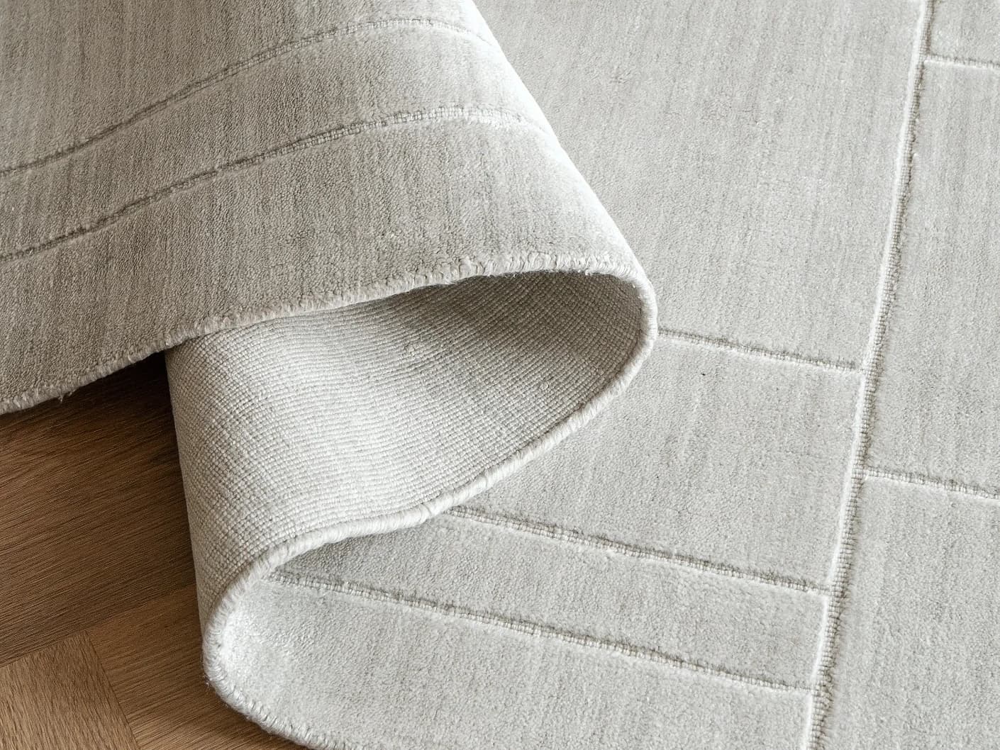 Elliot Ashton Round carpets in grey and silver, shown in a product close-up top view
