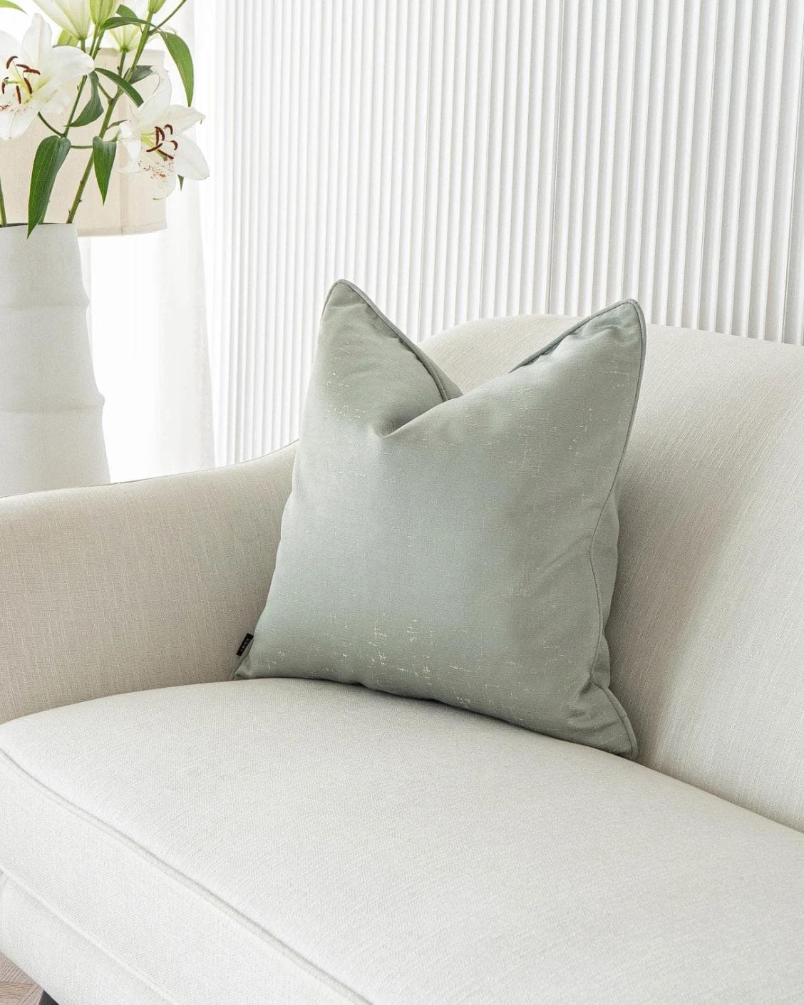 Lainie Sofia cushion in green and silver, shown in a lifestyle front view as image 2